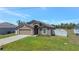Inviting single-story home featuring a neutral color palette, a manicured lawn, and an attached garage at 329 W Aster Ct, Poinciana, FL 34759