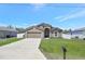 Charming single-story home with a well-manicured lawn, concrete driveway, and an attached two-car garage at 329 W Aster Ct, Poinciana, FL 34759