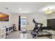 Bright home gym featuring modern exercise equipment, neutral walls, and beach views on the television at 329 W Aster Ct, Poinciana, FL 34759
