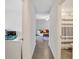 Hallway with hardwood floors leading into the living room with a sofa and bathroom with a shower at 329 W Aster Ct, Poinciana, FL 34759