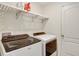 Laundry room featuring modern washer and dryer with white shelving above at 329 W Aster Ct, Poinciana, FL 34759