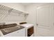 Laundry room featuring modern washer and dryer with white shelving above and a white door at 329 W Aster Ct, Poinciana, FL 34759