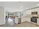 Open-concept kitchen and living room featuring stainless steel appliances and wood flooring at 329 W Aster Ct, Poinciana, FL 34759