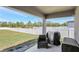 Covered patio featuring dark wicker furniture, a grill, and a view of the backyard and vinyl fence at 329 W Aster Ct, Poinciana, FL 34759