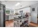 Bright kitchen with white cabinets, skylight, stainless steel appliances, and a functional rolling island at 4795 Myrtle View W Dr, Mulberry, FL 33860