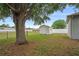 Large backyard with a storage shed and shaded by a mature tree on a sunny day at 541 Willet Cir, Auburndale, FL 33823