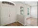 Inviting entryway featuring double doors, light wood-look flooring, and transom windows at 541 Willet Cir, Auburndale, FL 33823