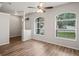 Bright living room with light wood-look flooring, a ceiling fan, and large windows at 541 Willet Cir, Auburndale, FL 33823