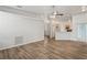 Open-concept living room features wood flooring and connects to kitchen with modern lighting at 541 Willet Cir, Auburndale, FL 33823