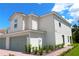 Side view of a neutral colored two-story home with red brick paver driveway and manicured landscaping at 603 Bay Leaf Dr, Poinciana, FL 34759
