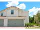 Charming two-story home with neutral siding, attached two-car garage, and beautiful landscaping at 603 Bay Leaf Dr, Poinciana, FL 34759
