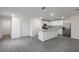A modern kitchen with gray wood flooring, a kitchen island, stainless steel appliances, and white cabinetry at 603 Bay Leaf Dr, Poinciana, FL 34759