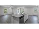 A modern kitchen with gray wood flooring, a kitchen island, and granite countertops at 603 Bay Leaf Dr, Poinciana, FL 34759