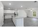 A modern kitchen with gray wood flooring, a kitchen island, stainless steel appliances, and white cabinetry at 603 Bay Leaf Dr, Poinciana, FL 34759