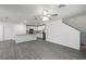 Modern kitchen with gray wood floors, granite countertops, stainless steel appliances, and white cabinetry at 603 Bay Leaf Dr, Poinciana, FL 34759
