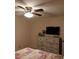 Comfortable main bedroom with ceiling fan, dresser, and a large window at 3400 Ne 43Rd Pl, Ocala, FL 34479