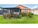 Backyard with screened-in porch and beautiful landscaping at 505 Millifiora Ln, Kissimmee, FL 34759