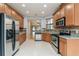 Modern kitchen with stainless steel appliances, granite counters, and wooden cabinets, offering ample storage space at 505 Millifiora Ln, Kissimmee, FL 34759