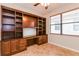 Office featuring tile floors, built-in shelves and desk near window at 505 Millifiora Ln, Kissimmee, FL 34759