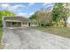 Spacious driveway leading to a carport alongside a cozy single-story home under a partly cloudy sky at 803 Mccranie Rd, Lakeland, FL 33809