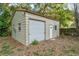 Exterior of standalone corrugated metal garage with white door in wooded backyard at 803 Mccranie Rd, Lakeland, FL 33809