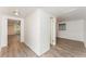 Bright hallway featuring wood-look flooring, white walls and connecting doors to other rooms at 803 Mccranie Rd, Lakeland, FL 33809