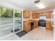 Bright kitchen featuring wood cabinets, tile floors, and a sliding glass door to backyard at 803 Mccranie Rd, Lakeland, FL 33809