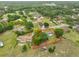 Aerial view of a charming home surrounded by mature trees on a large lot outlined in red at 9210 Lehall W Sq, Lakeland, FL 33810