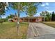 Charming single-story home featuring a carport and well-maintained front yard with mature trees and a mailbox at 4912 Marla Ave, Lakeland, FL 33812