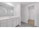 Bright bathroom features a modern vanity with a large mirror and a walk-in closet with shelving at 2214 Pecos Ct, Poinciana, FL 34759
