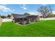 Lush backyard featuring a screened-in pool area, grass, and fence at 4014 Gallagher Loop, Casselberry, FL 32707