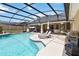 Sparkling private pool with a screened-in enclosure, lounge chairs, and outdoor grill at 4014 Gallagher Loop, Casselberry, FL 32707