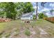 Large backyard with a detached garage and a cozy fire pit area surrounded by mature trees, perfect for outdoor gatherings at 7220 Pinehaven Dr, Lakeland, FL 33810