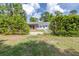 Scenic backyard with a charming covered patio, a refreshing pool, lush greenery, and a serene outdoor living space at 7220 Pinehaven Dr, Lakeland, FL 33810