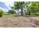 Expansive backyard featuring a detached garage with ample space and a large tree, ideal for outdoor activities and storage at 7220 Pinehaven Dr, Lakeland, FL 33810