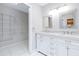 Bathroom with double vanities, white marble countertops, and a walk-in closet at 7220 Pinehaven Dr, Lakeland, FL 33810