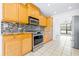 Updated kitchen featuring stainless steel appliances, granite countertops, and tile backsplash at 7220 Pinehaven Dr, Lakeland, FL 33810
