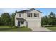 Charming two-story home features a symmetrical facade, attached garage, and landscaping at 1321 Acorn Meadow Loop, Eustis, FL 32726