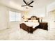 Elegant bedroom with a decorative wood frame bed, complemented by matching nightstands and marble floors at 2735 Berkford Cir, Lakeland, FL 33810