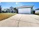 Attractive home exterior with a wide driveway, well-maintained lawn, and mature landscaping at 2735 Berkford Cir, Lakeland, FL 33810