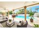 Covered outdoor pool area with neutral furniture, travertine floors, and manicured landscaping at 2735 Berkford Cir, Lakeland, FL 33810