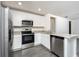 Well-equipped kitchen showcasing white cabinets, stainless steel appliances, and a practical island with granite countertops at 3824 Corsican Pl, Lake Alfred, FL 33850