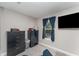 Bedroom featuring neutral walls, gray carpet, window with curtains, and television at 350 N 1St Ave, Bartow, FL 33830