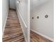 Stairway with wood-look steps, a white railing, and neutral walls adorned with decorative accents at 350 N 1St Ave, Bartow, FL 33830