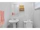 Clean bathroom featuring a pedestal sink and comfort-height toilet, maximizing space and functionality at 4915 Whiteoak E Dr, Lakeland, FL 33813