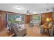 Comfortable living room with wood paneling, ceiling fan, and sliding glass doors to a deck at 4915 Whiteoak E Dr, Lakeland, FL 33813