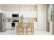 Bright kitchen featuring white cabinets, stainless steel appliances, and stylish pendant lighting at 2627 Skyline Loop, Kissimmee, FL 34758