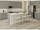 Modern kitchen with gray cabinetry, stainless steel appliances, a center island with seating, and light wood flooring at 6229 Sw 96Th Pl, Ocala, FL 34476