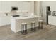 Modern kitchen featuring white cabinetry, stainless steel appliances, and a spacious island with bar stool seating at 6237 Sw 96Th Pl, Ocala, FL 34476