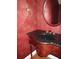 Elegant powder room featuring dark granite countertop, a stylish sink, and beautiful red textured walls at 665 Oak Harbour Dr # 115, Altamonte Springs, FL 32701